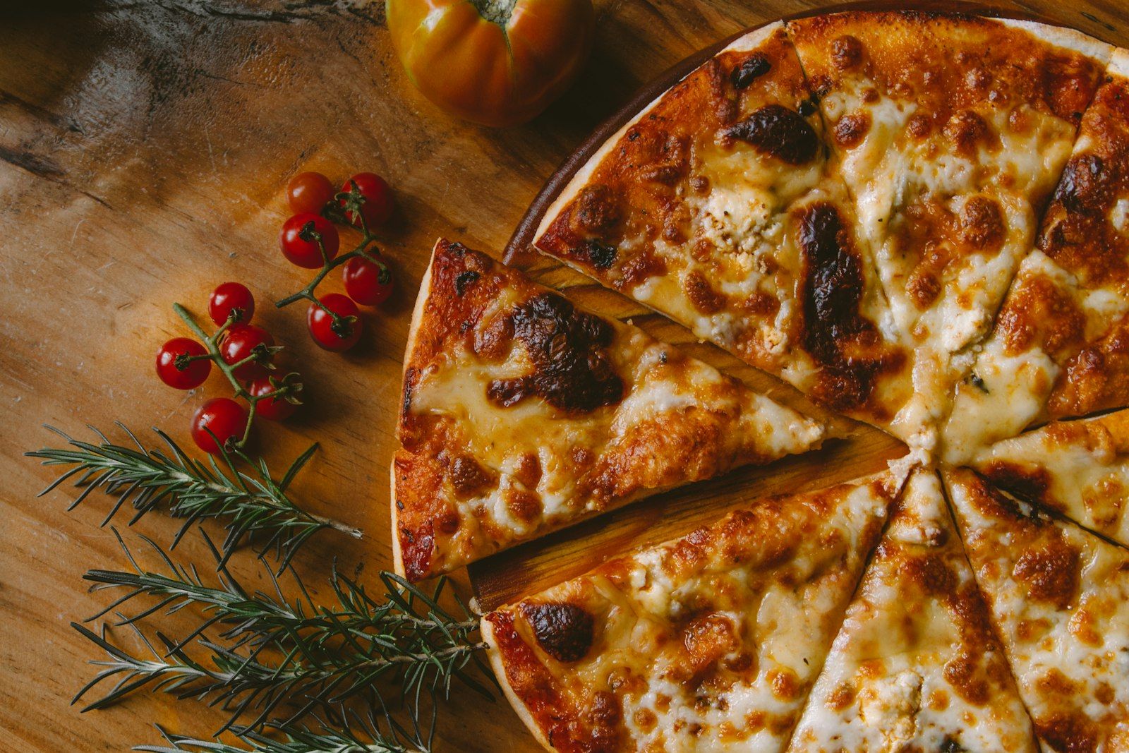 Chef sliding a pizza into a wood-fired oven
