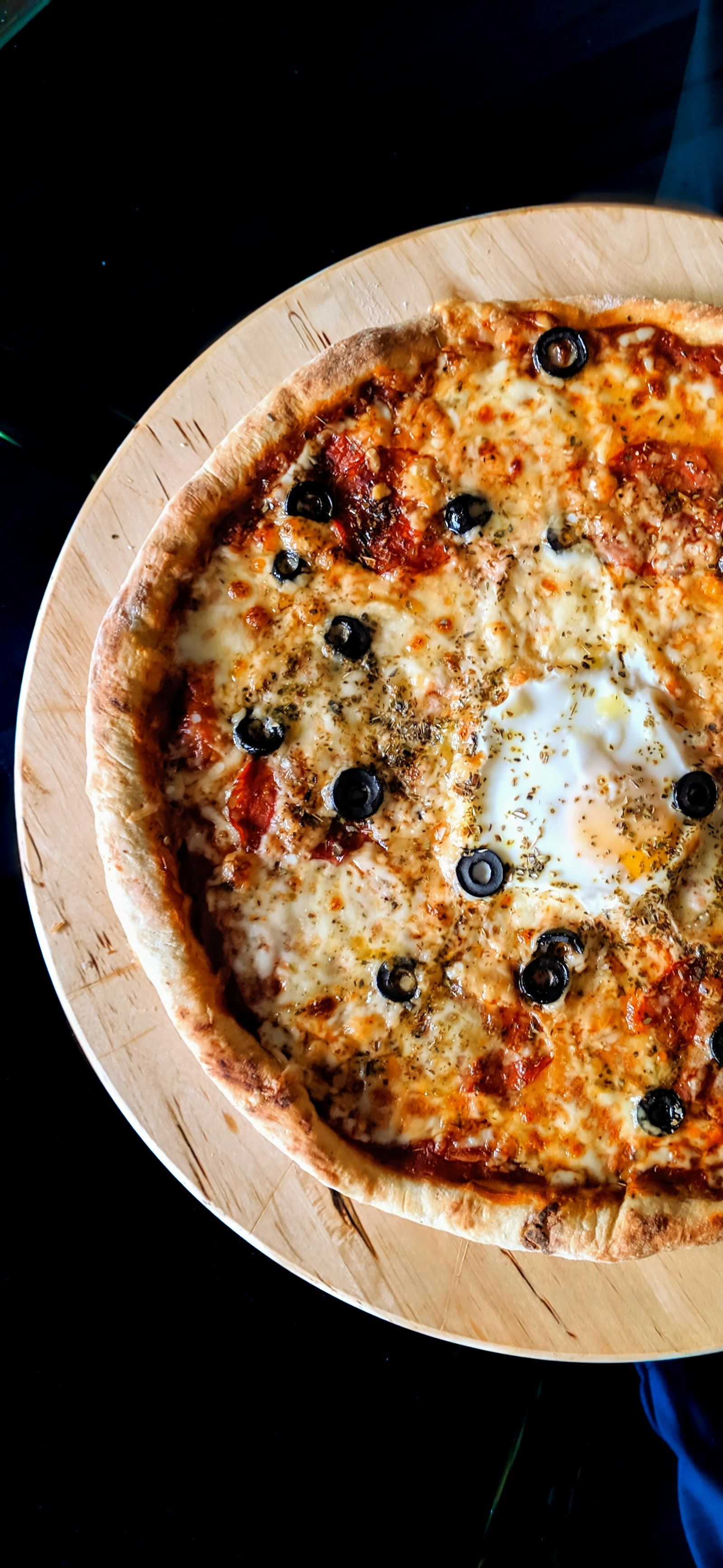 Sliced pizza on a wooden board with herbs